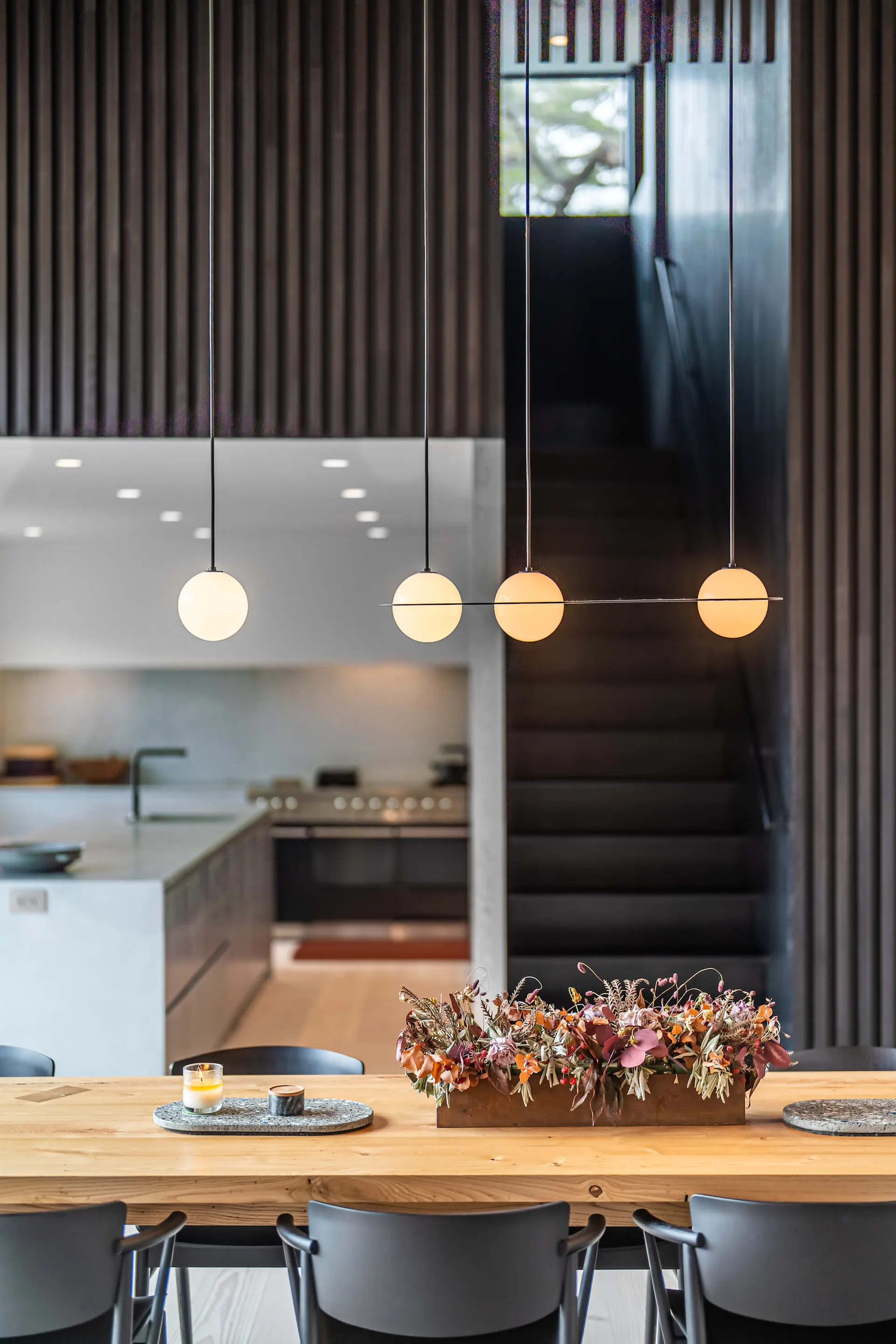 Kitchen with pendant lights and a staircase at the Westchester Residence, lighting control by PSE