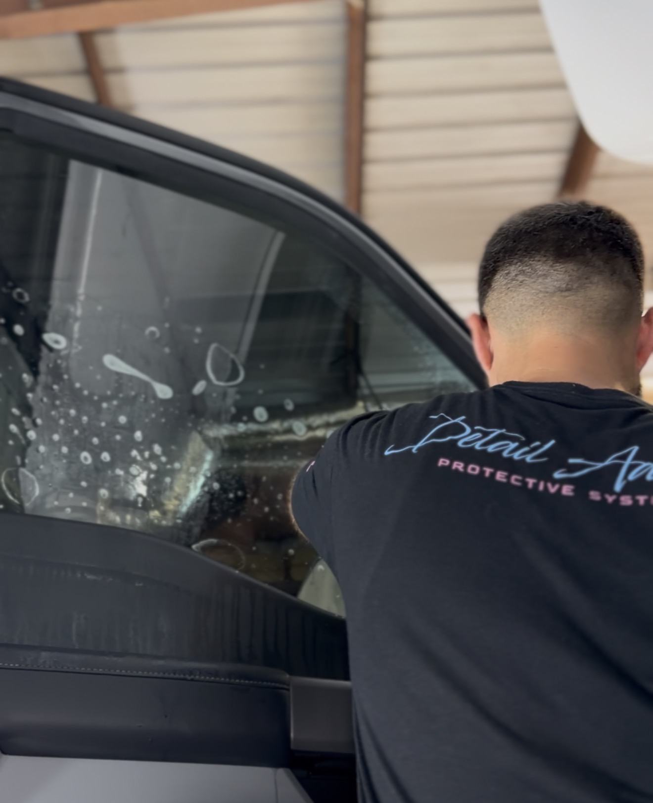 White Cadillac SUV with tinted windows at Detail Addict