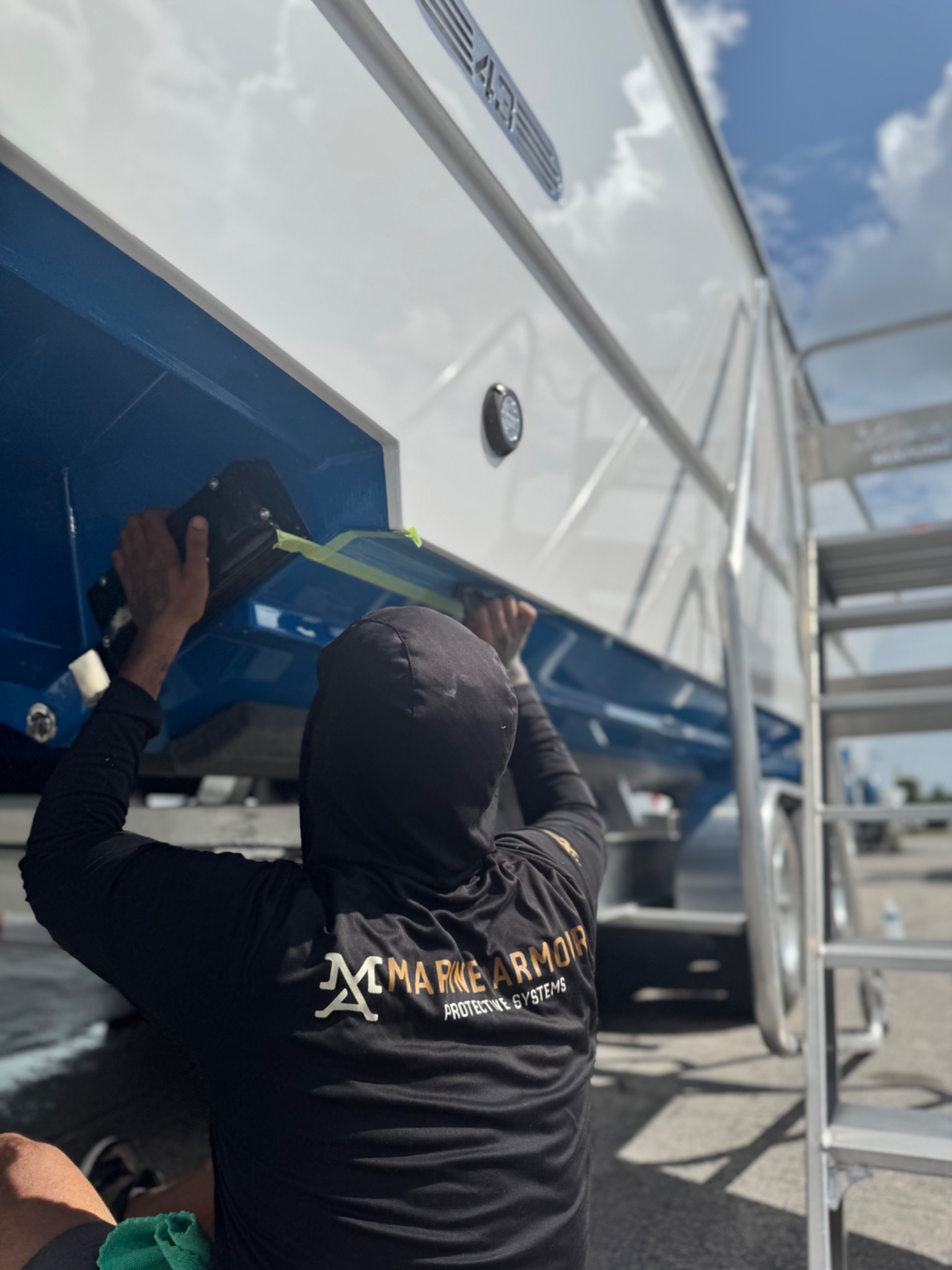 Technician working on the underside of a boat at Detail Addict