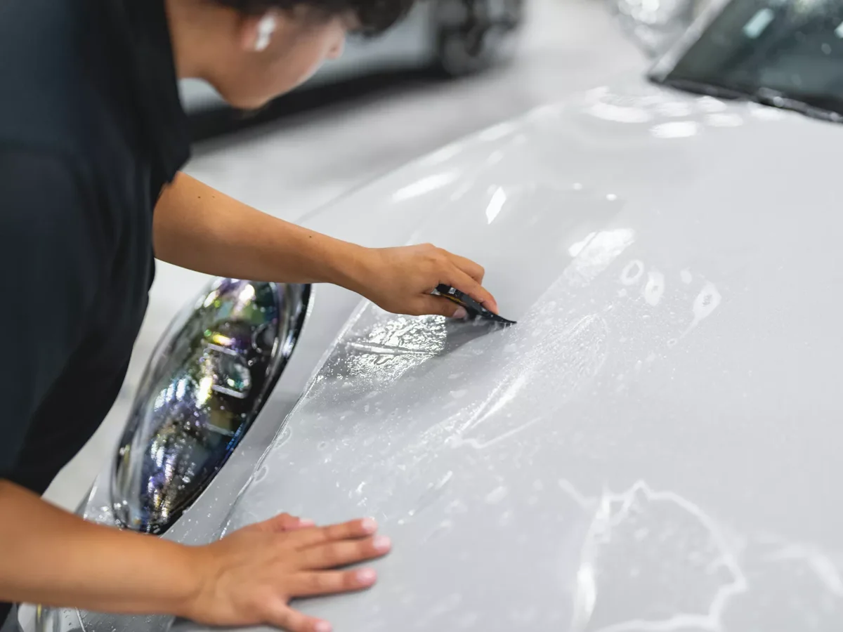 XPEL paint protection film being installed on a white vehicle