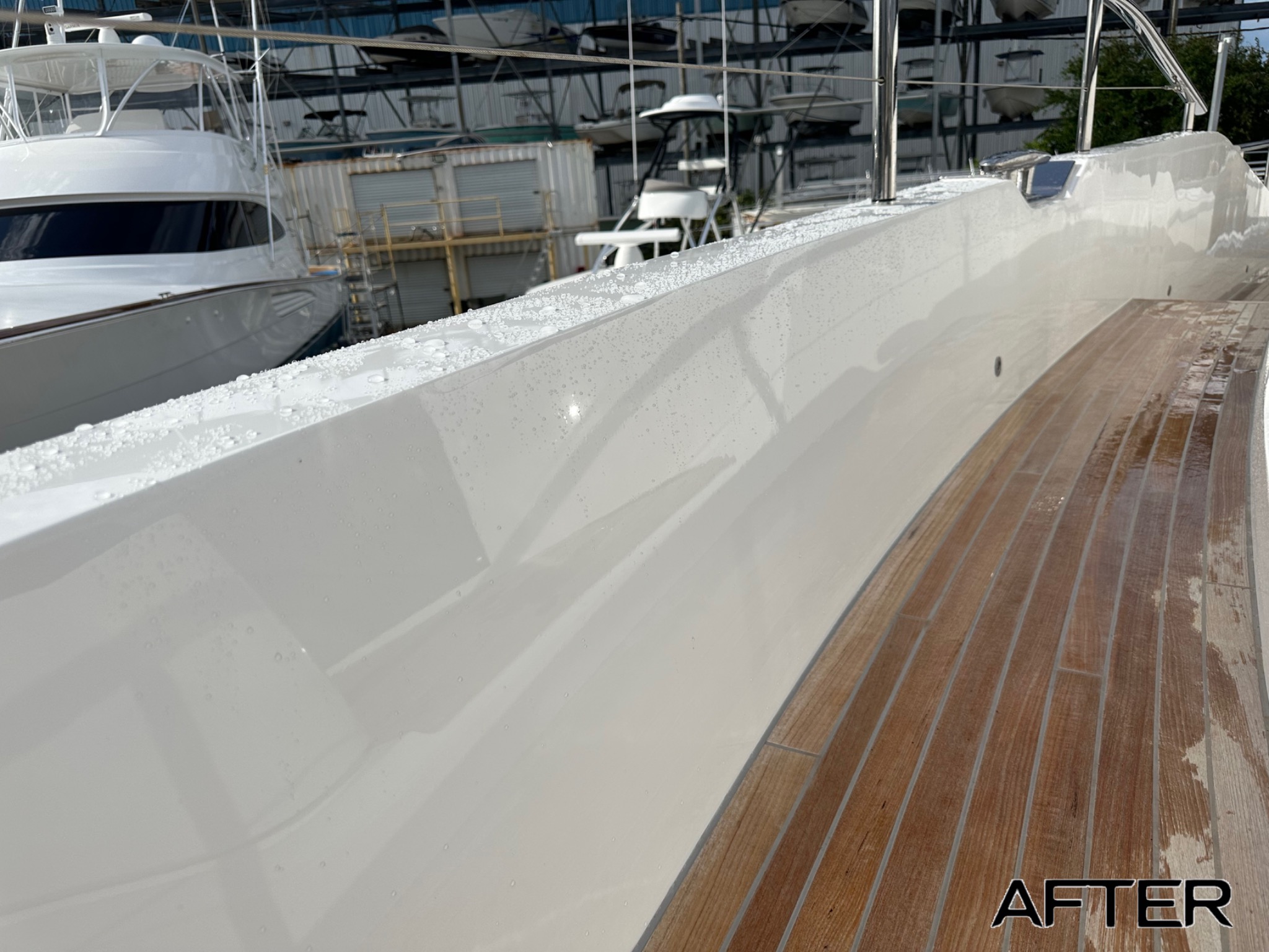 After: glossy white boat hull side beside teak decking