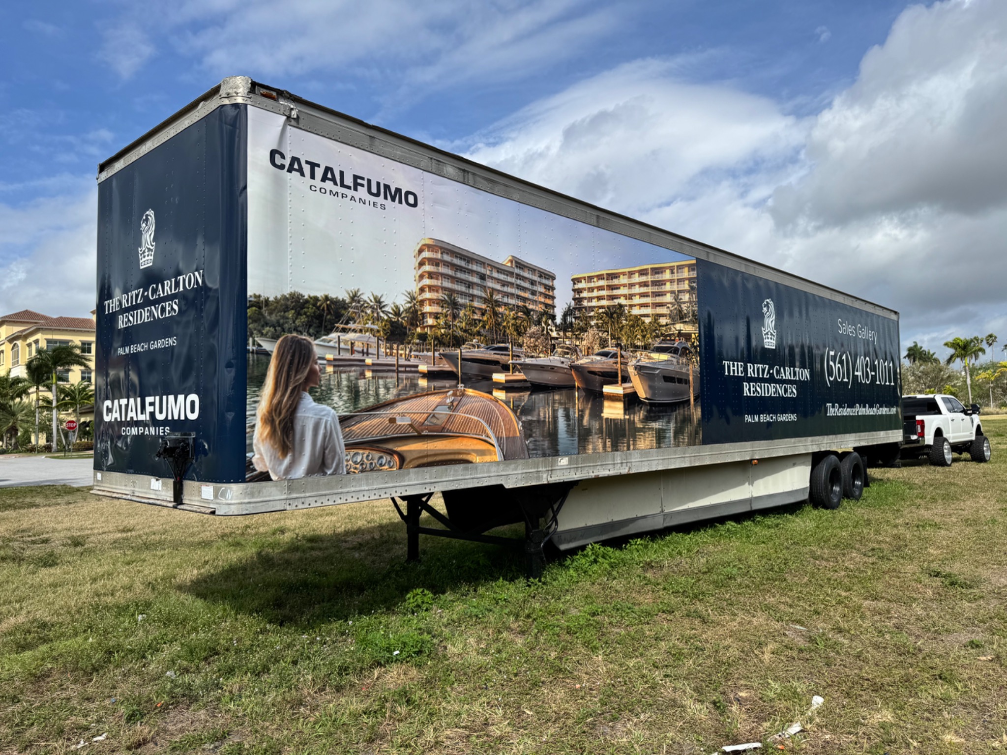 Angled view of the wrapped commercial trailer showing front and side graphics