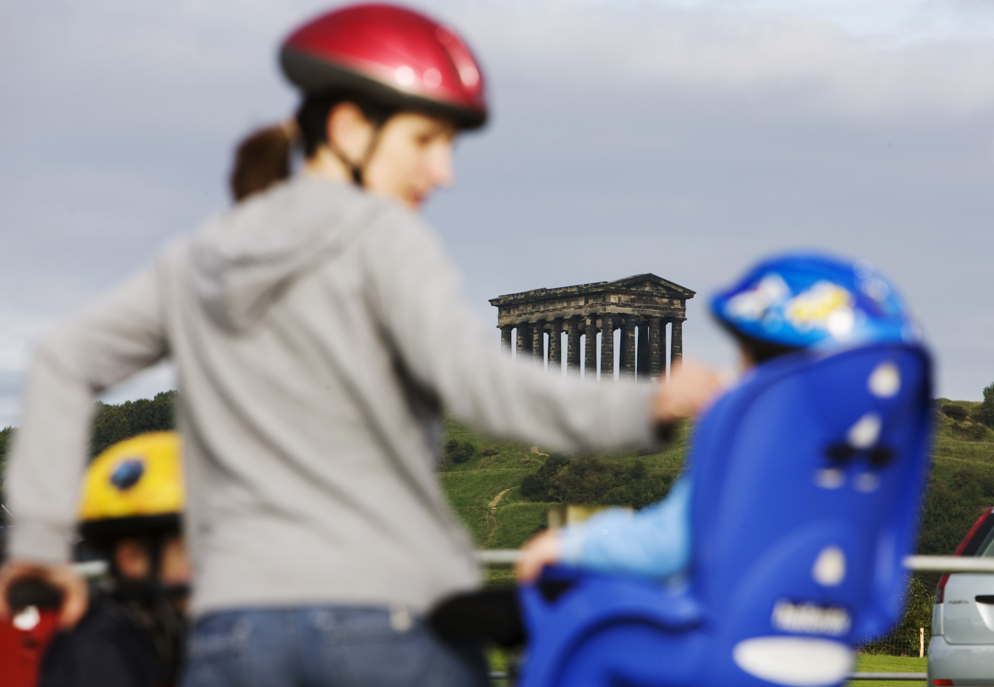 A woman on a bike with a child in a bike seat at Herrington Country Park