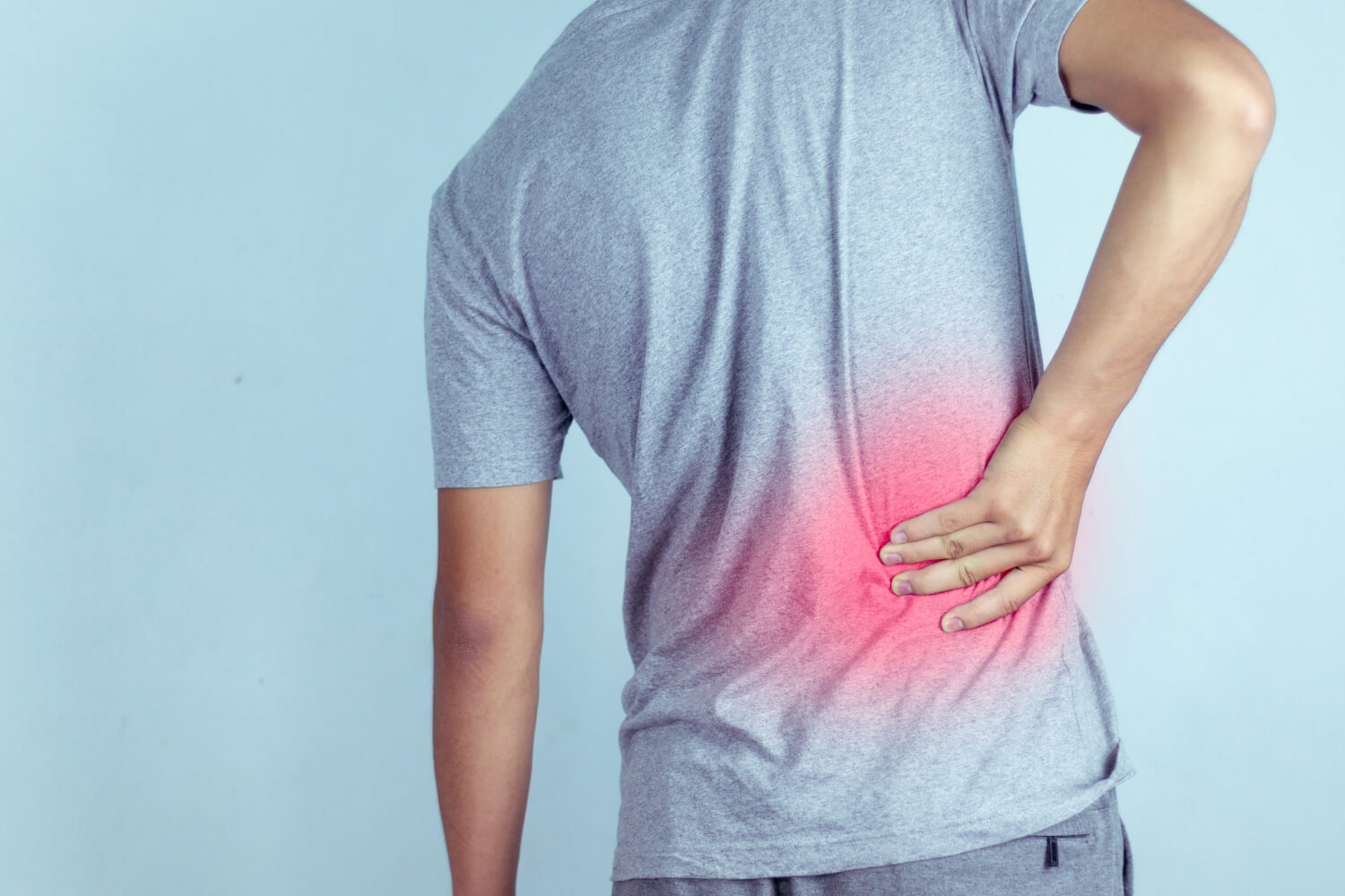 Man holding lower back in pain, red highlight.