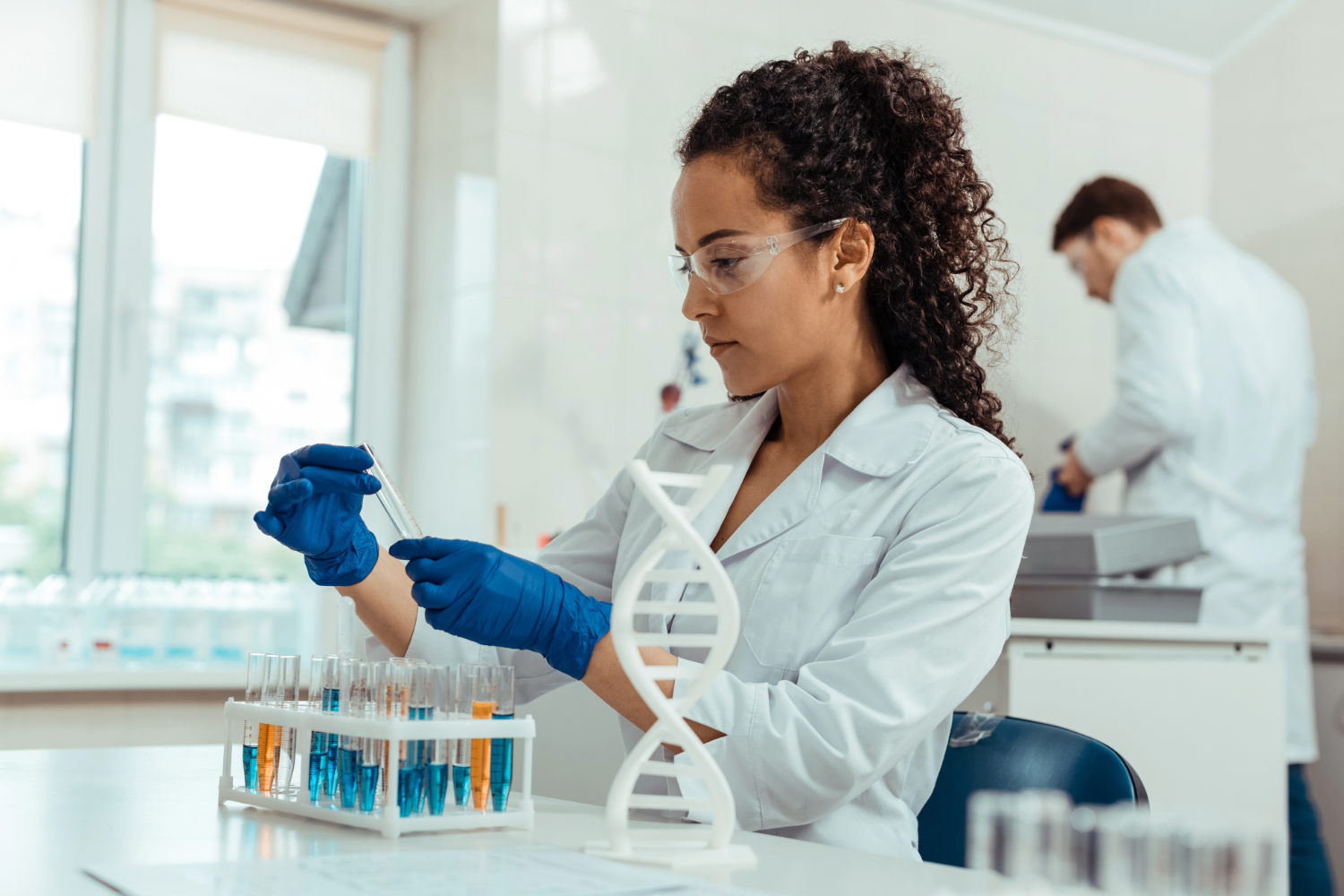 Female scientist examining test tube in lab.