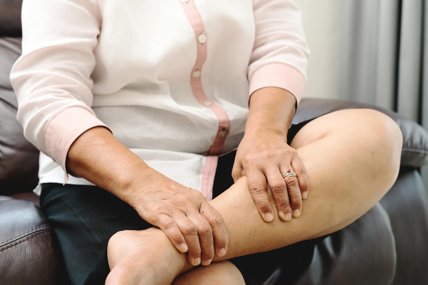 Woman holding leg, signaling pain.