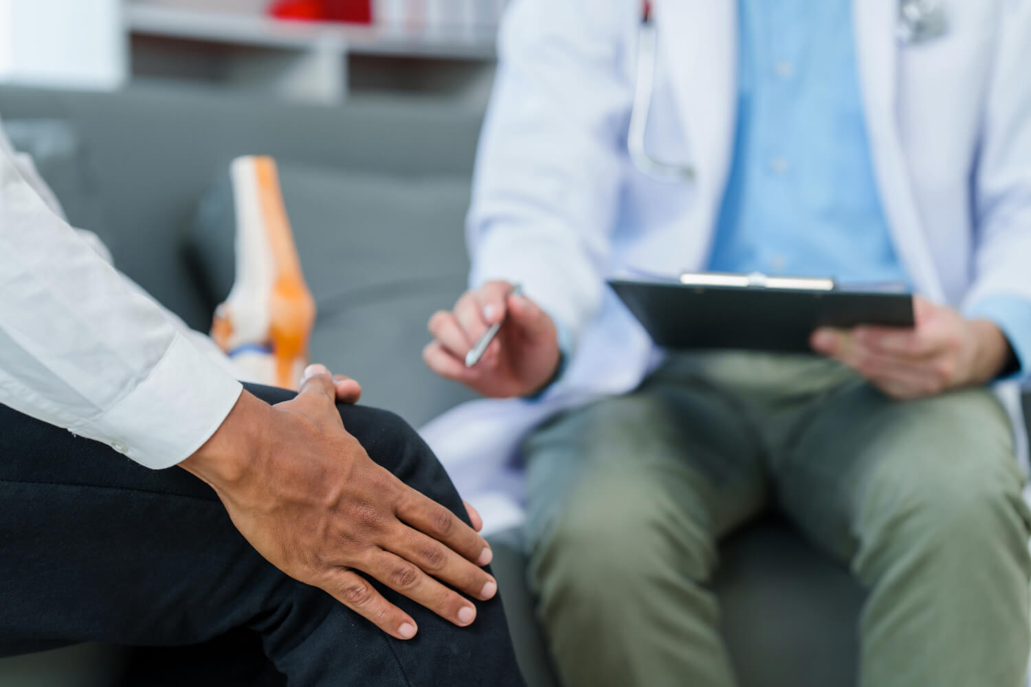 Doctor consults patient about knee pain.
