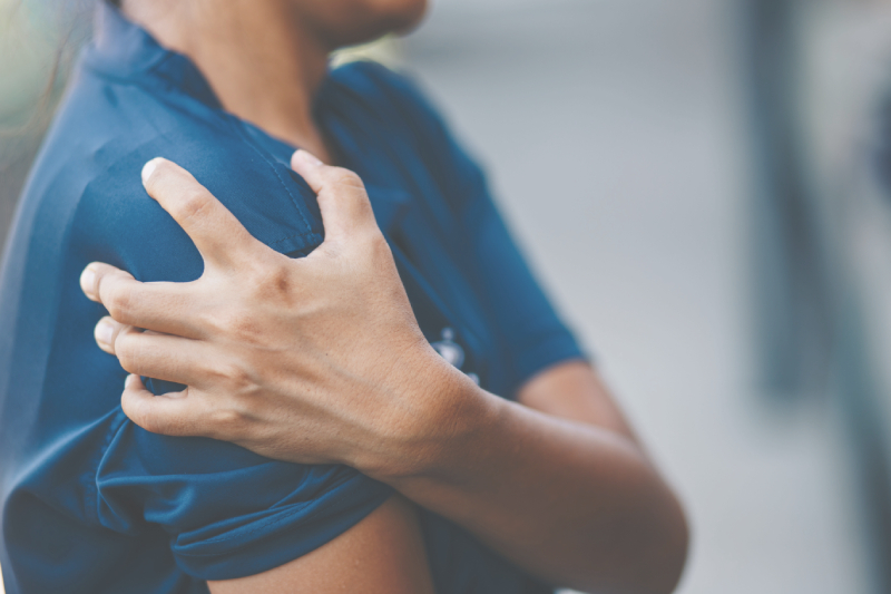Person holding shoulder in pain.