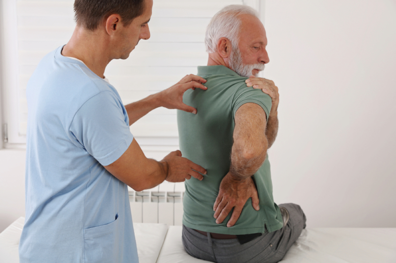 Doctor examining man's back pain