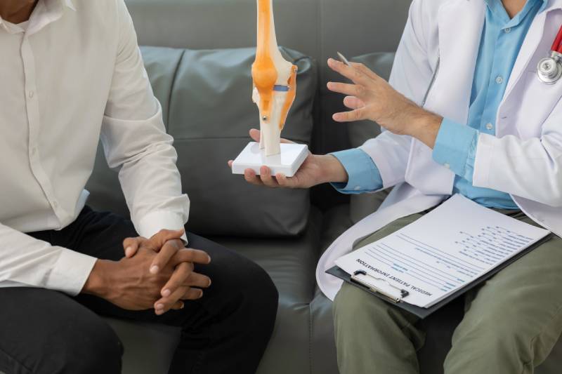 Doctor explaining knee model to patient