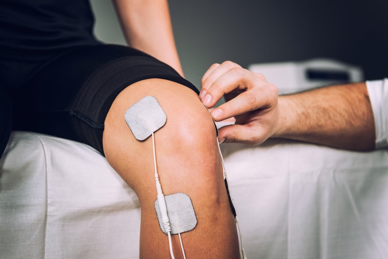 Patient receiving knee electrotherapy at Greater Austin Pain Center, TX.