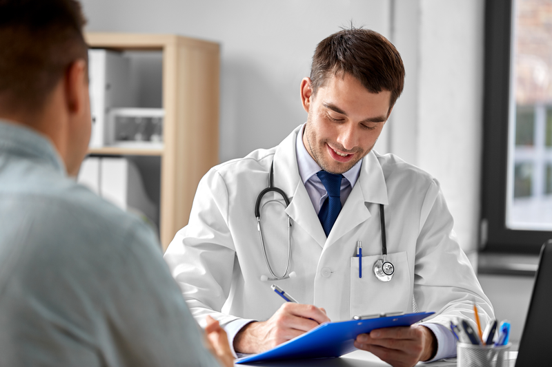 Doctor in white coat consults male patient.