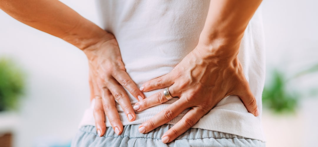 Person holding lower back in pain.