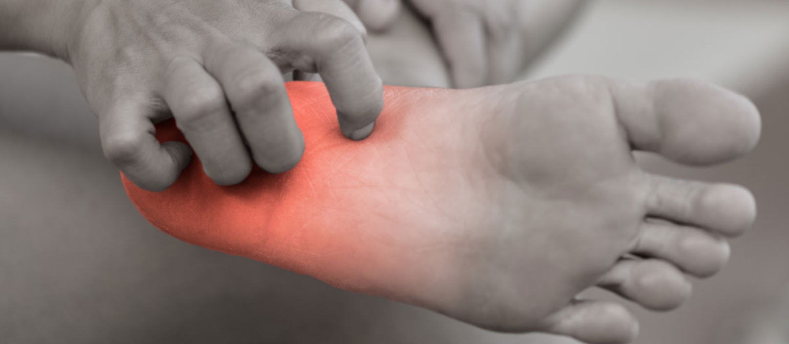 Person holding foot with red highlighting pain