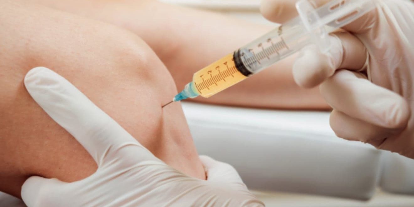 Medical professional administering injection into knee