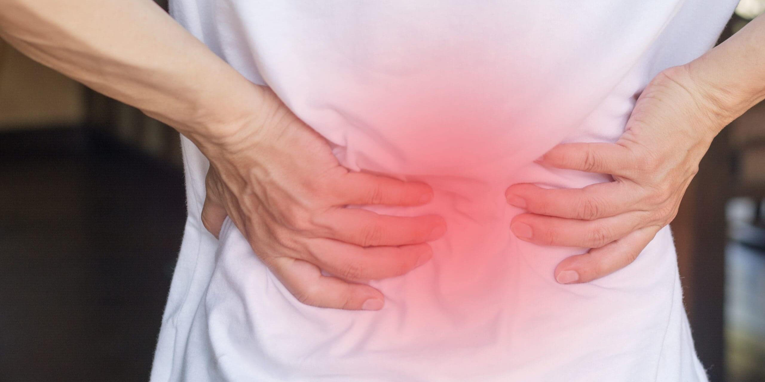 Person holding lower back in pain.