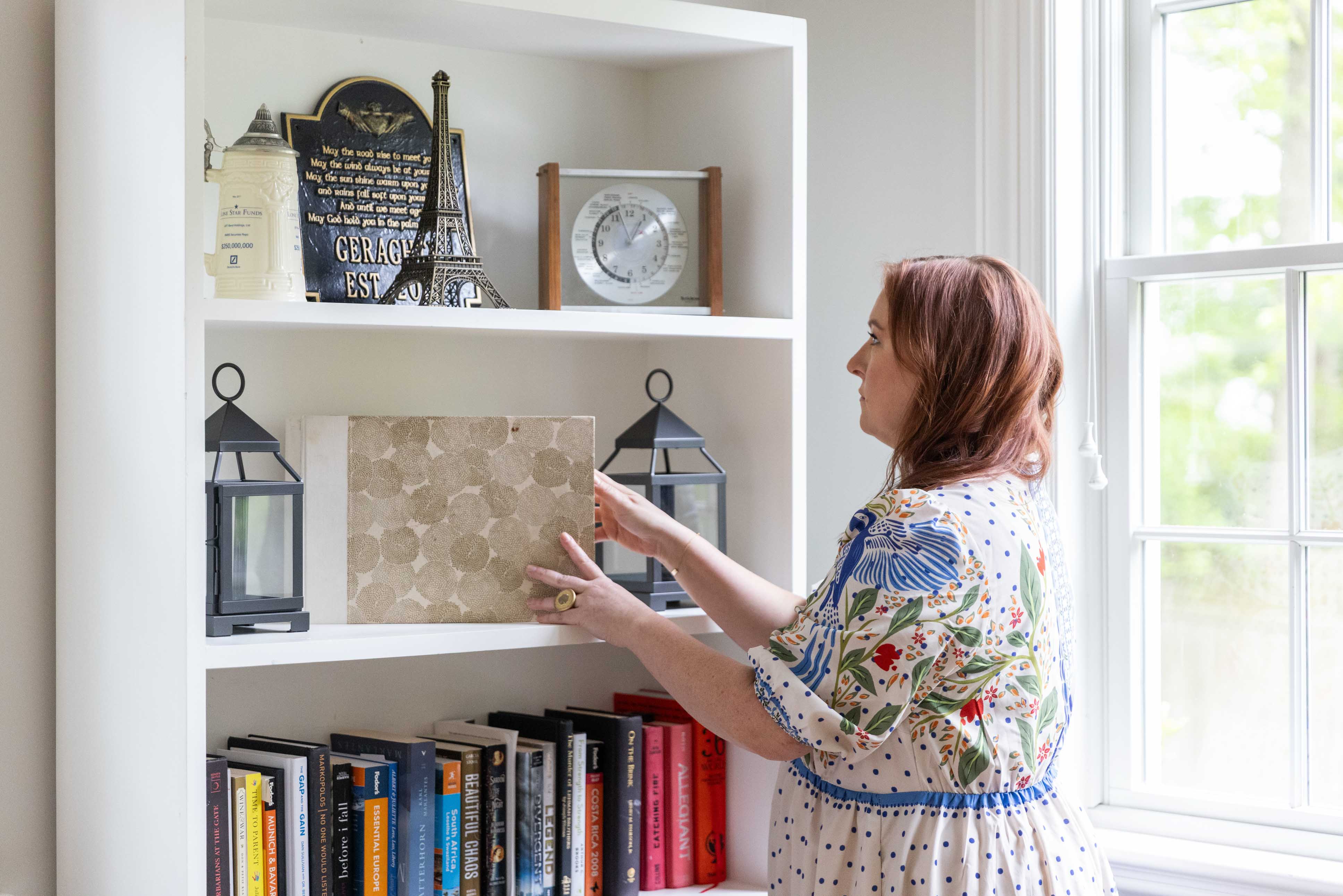 Katie Neary, organizer at Haven NY, adjusting a shelf's items