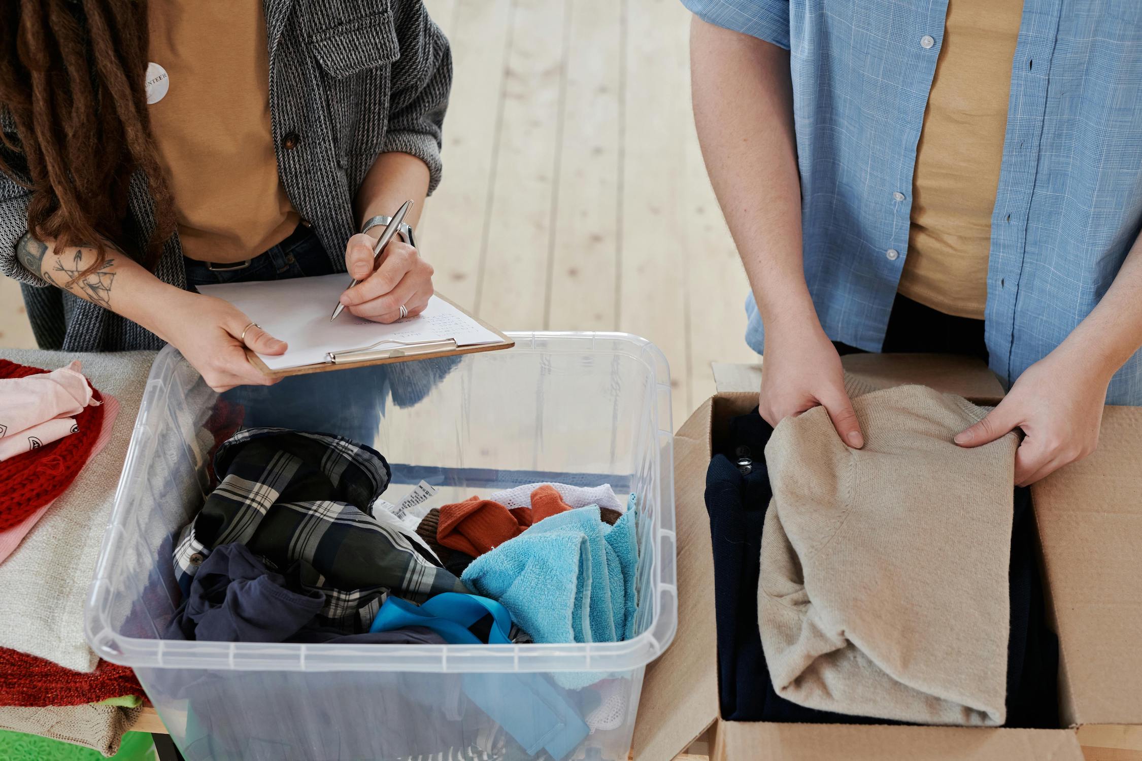 People organizing bin of clothes