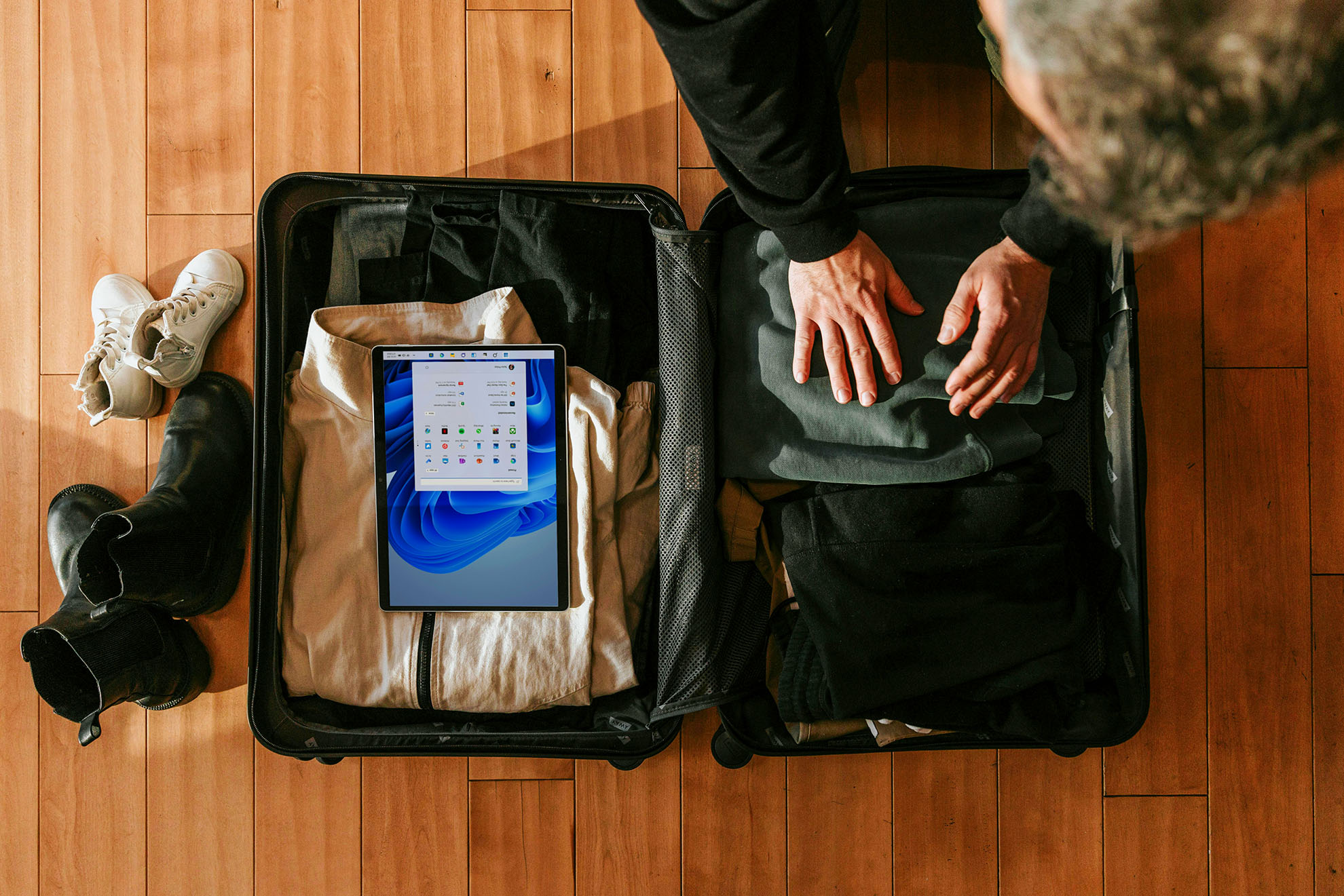Person packing a suitcase neatly.