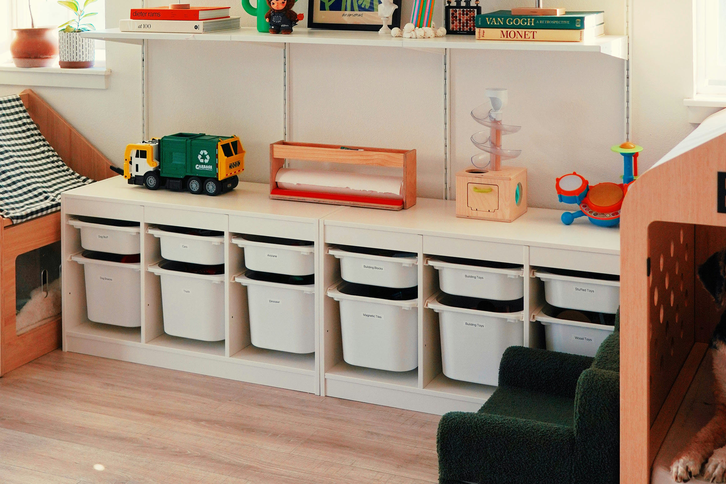 Montessori style toy storage with pullout buckets and a few toys on top.