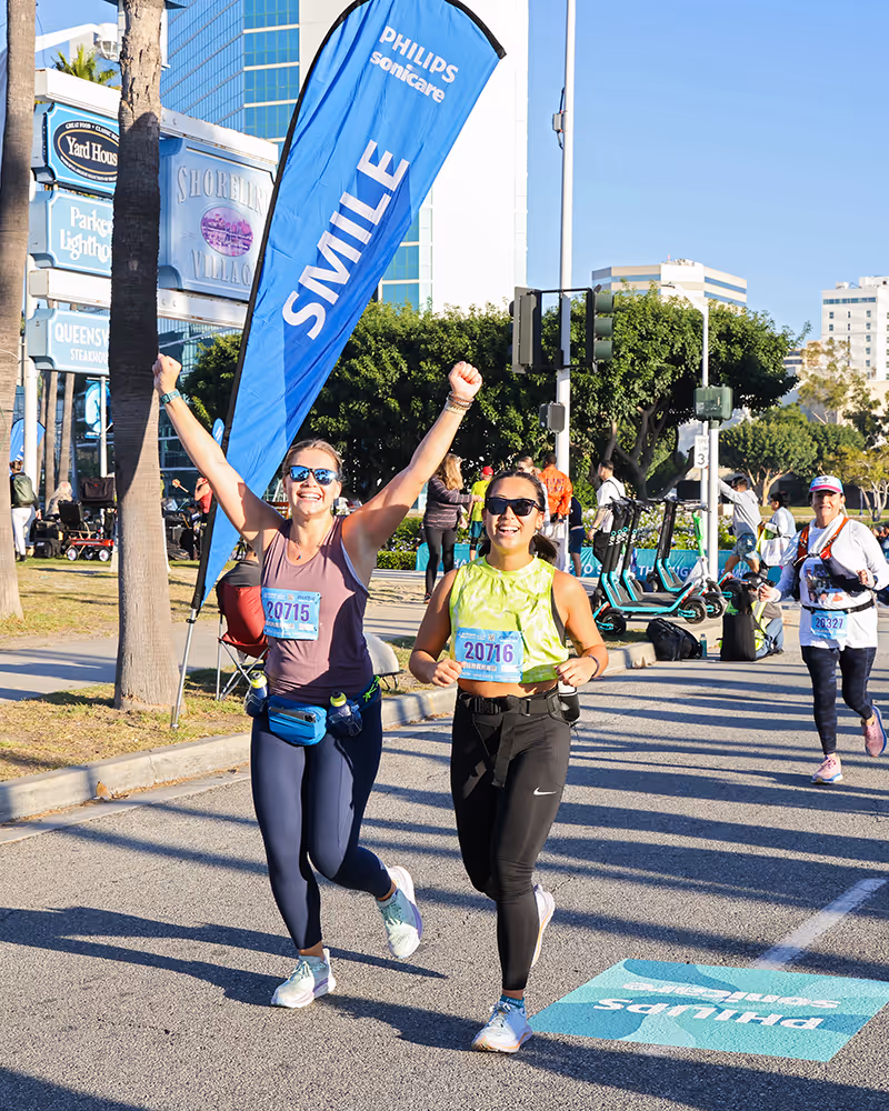 Two people cheering and running in a marathon