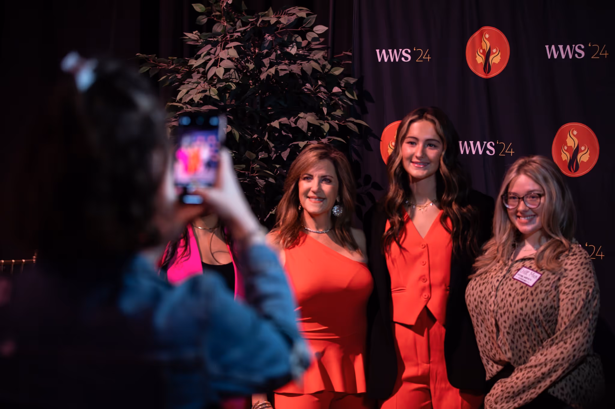 A person taking a photo of a group of women