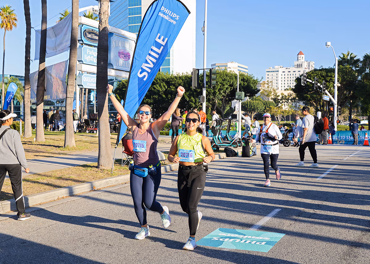 Two women cheering and running in marathon