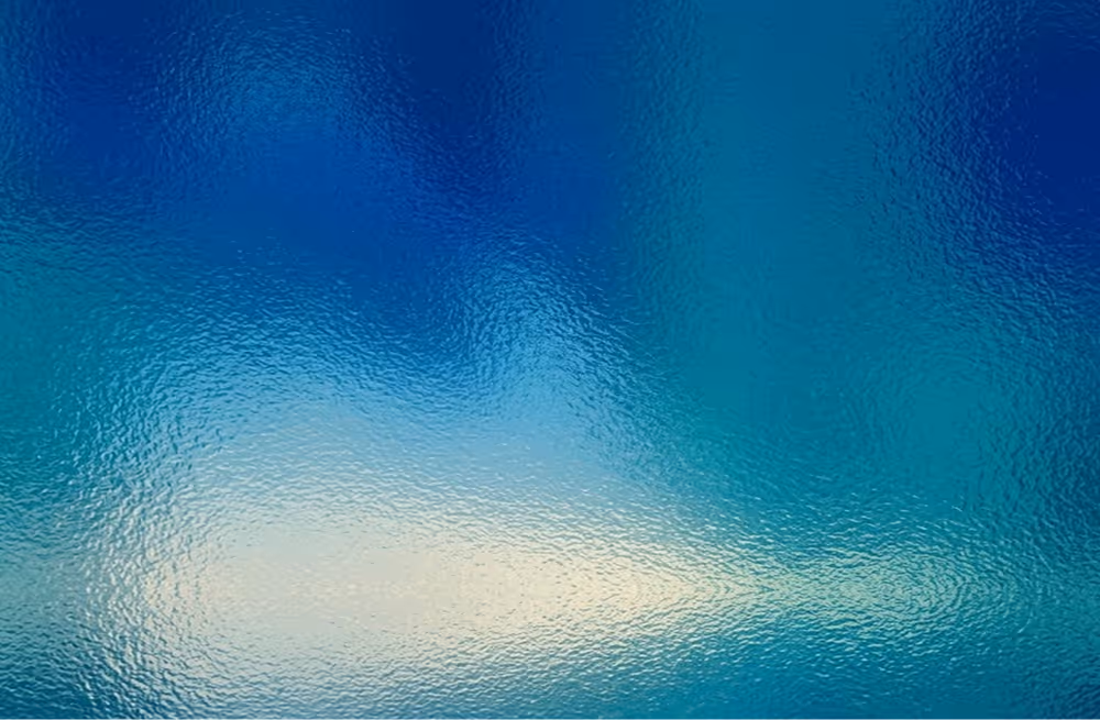 Abstract blurred blue and teal gradient background with a light reflection effect.