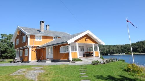 Oransj hus ved vannet
