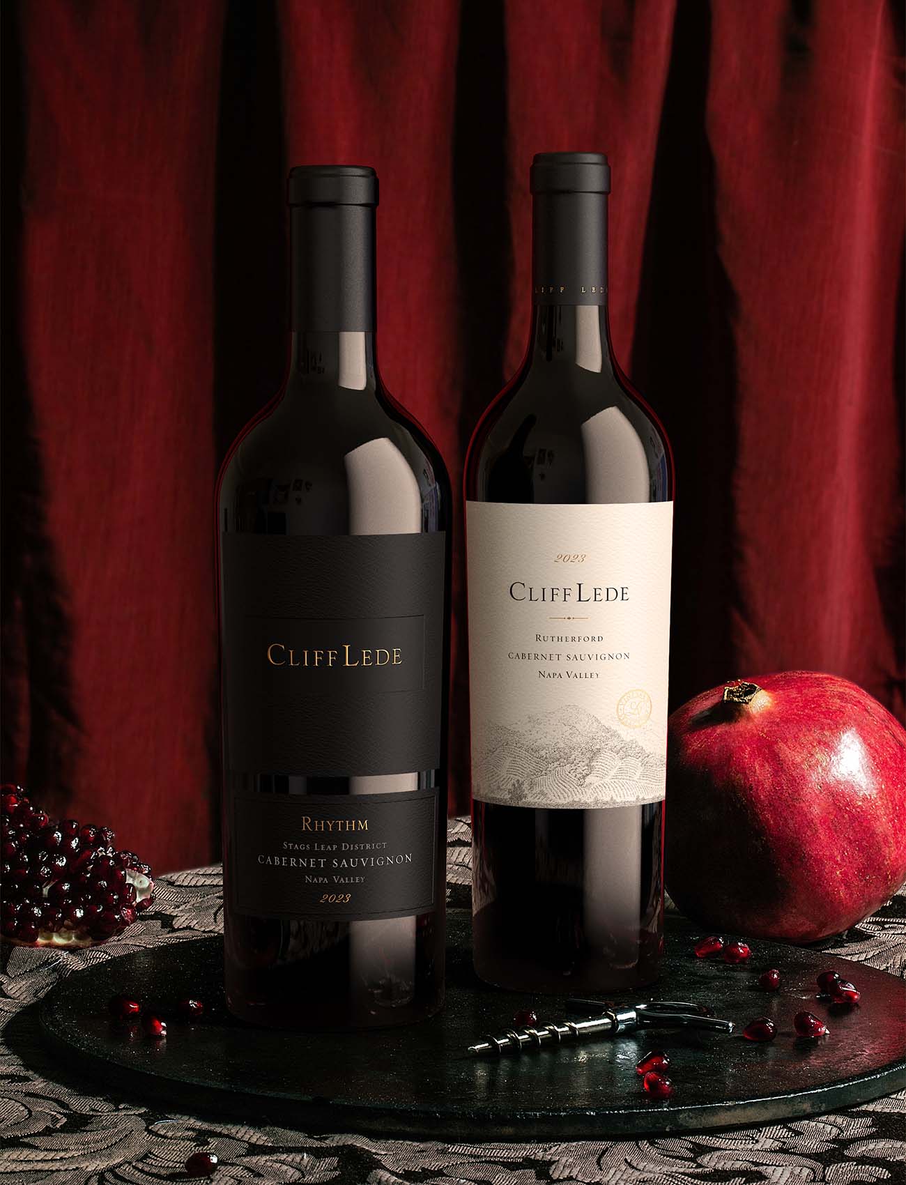 2 premium Napa Valley Cabernet Sauvignon bottles in an elegant decor with red drapery and pomegranate