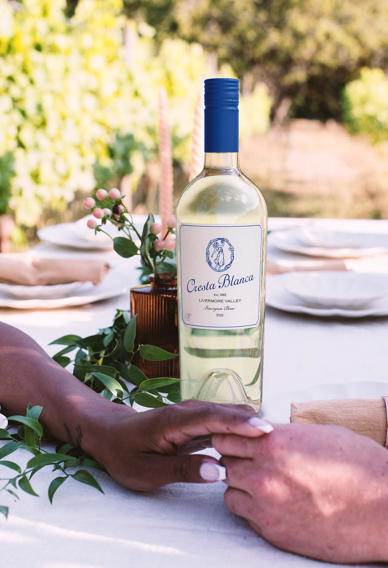 Lifestyle wine photography showing a chilled white wine bottle on an outdoor table, capturing a relaxed, social drinking moment.