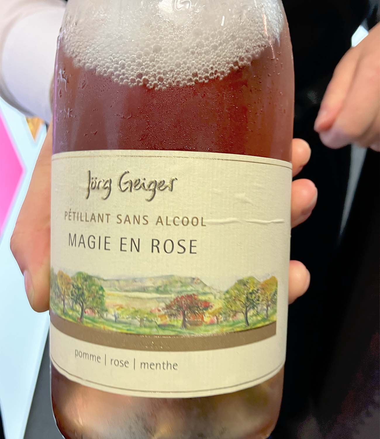 Close-up of alcohol-free rosé wine bottle labeled MAGIE EN ROSE displayed at a no-alcohol beverage stand at Wine Paris