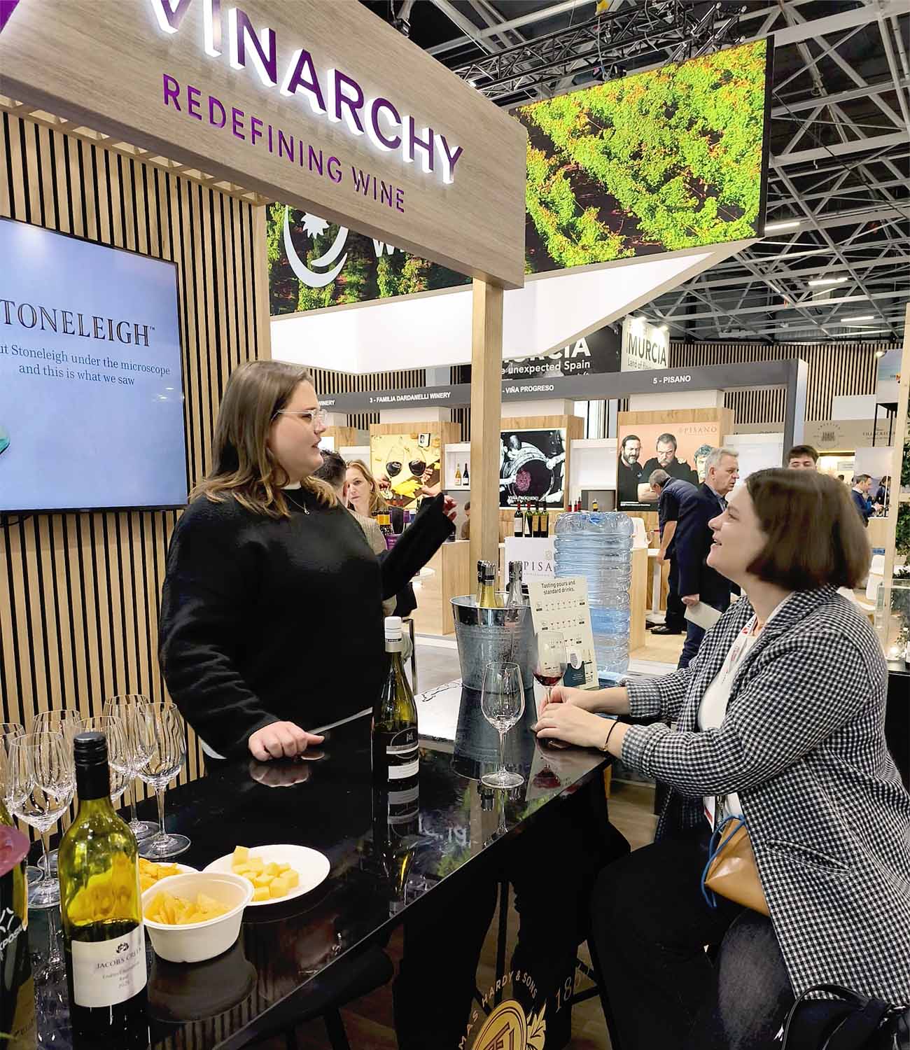 Wine tasting at Vinarchy producer booth during Wine Paris with visitors sampling wines and discussing products
