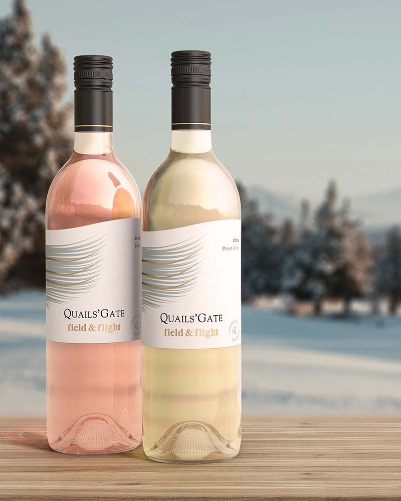 bottle of rosé and pinot grigio on a wooden tabletop outside in winter time