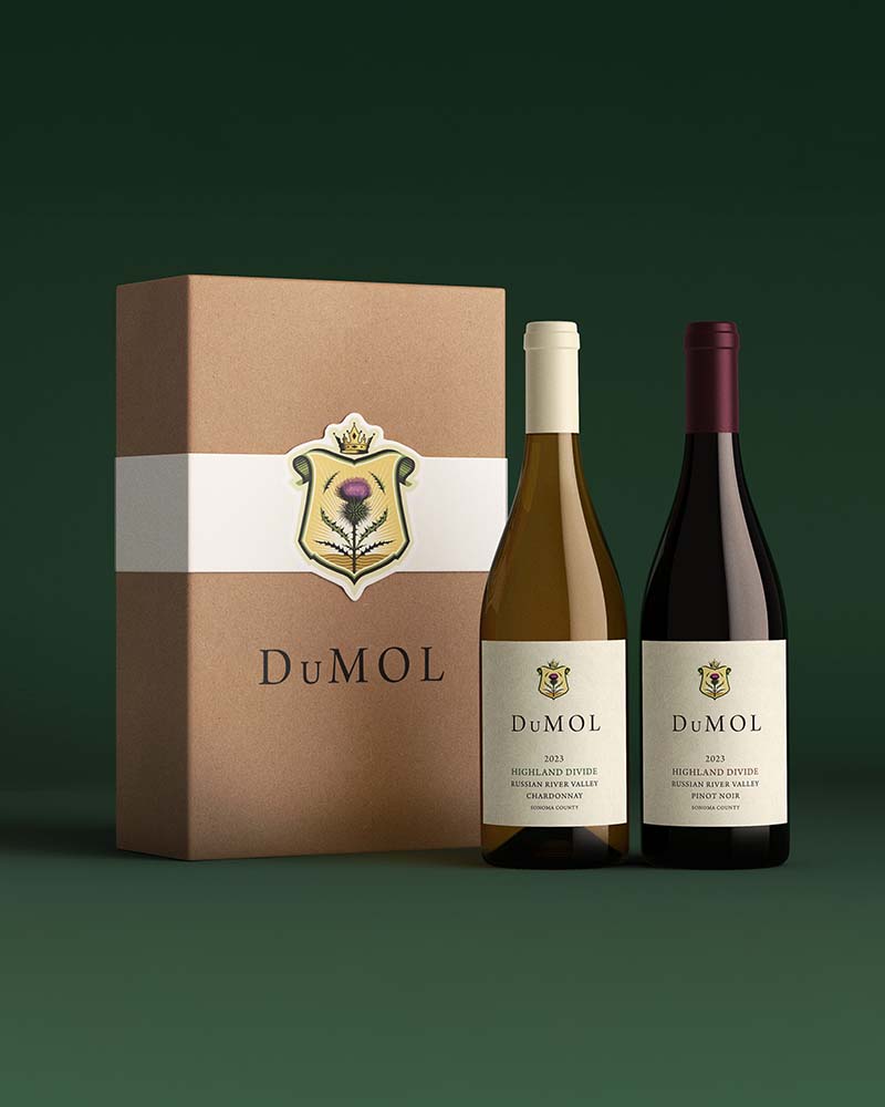 cardboard wine box next with to a Chardonnay and Pinot Noir bottle in a dark green environment by Outshinery