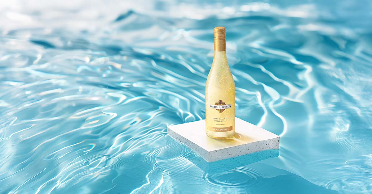 bottle of low calorie Chardonnay on a slab on concrete floating in a swimming pool