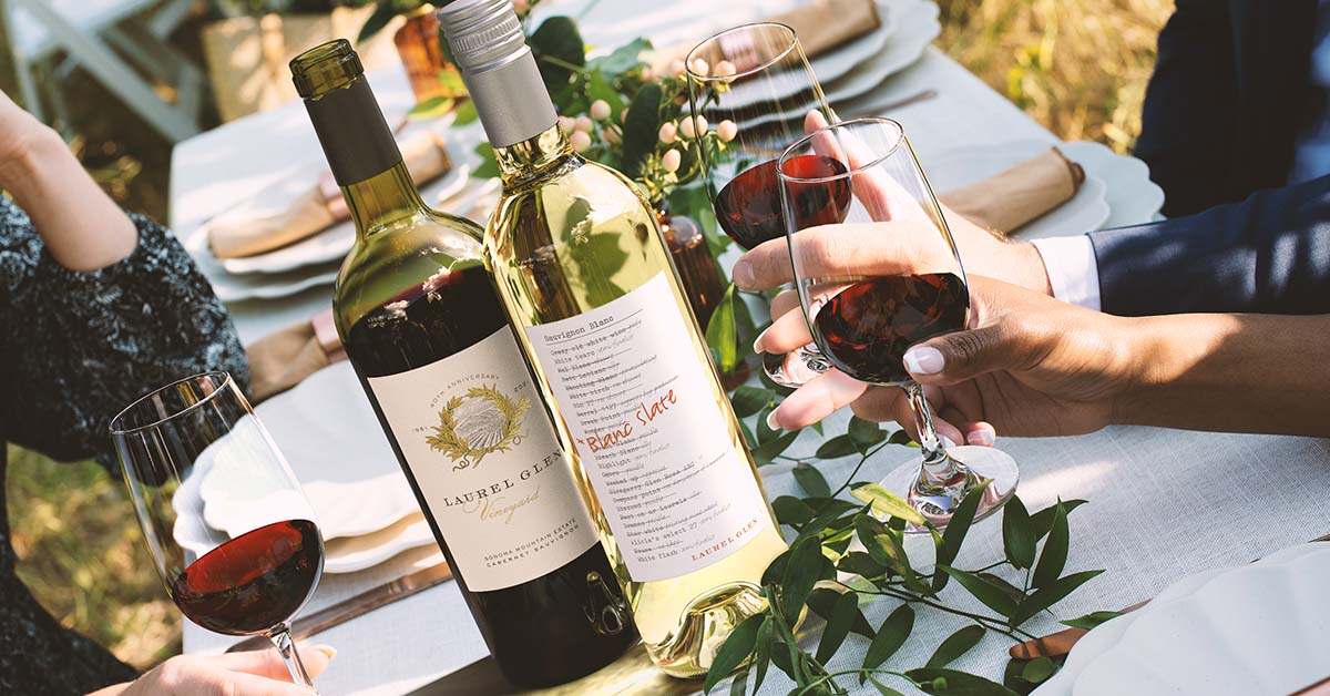 Premium wine bottles with custom labels displayed on an elegant table setting with food pairings – Outshinery professional product photography