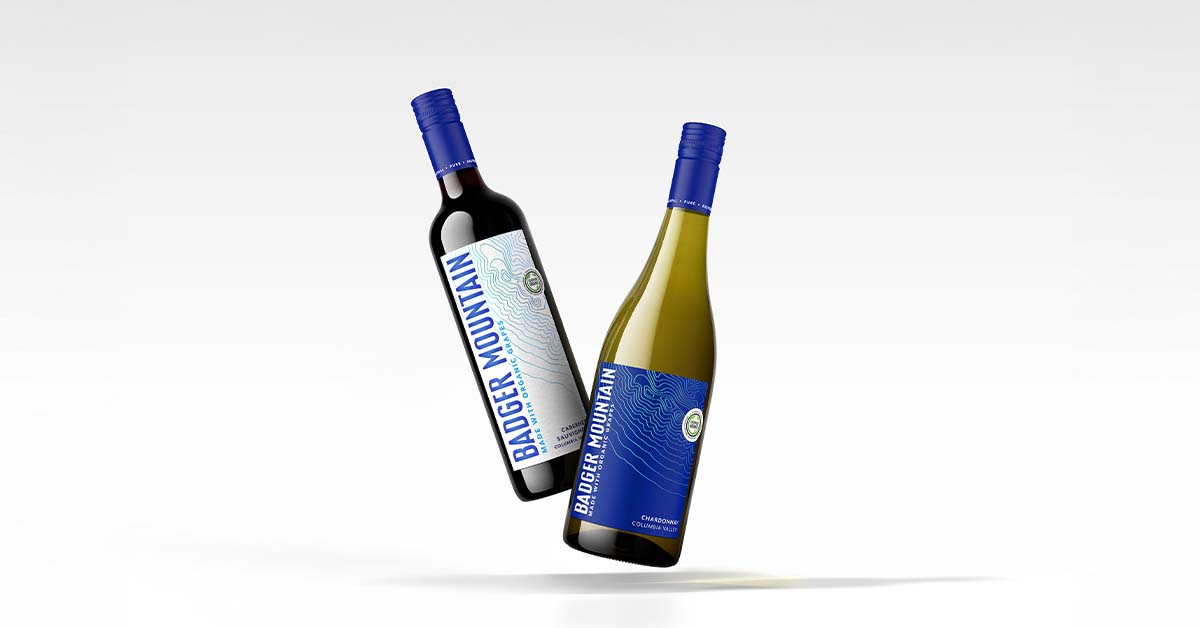 Cabernet Sauvignon and Chardonnay bottles from Columbia Valley floating above a white table top