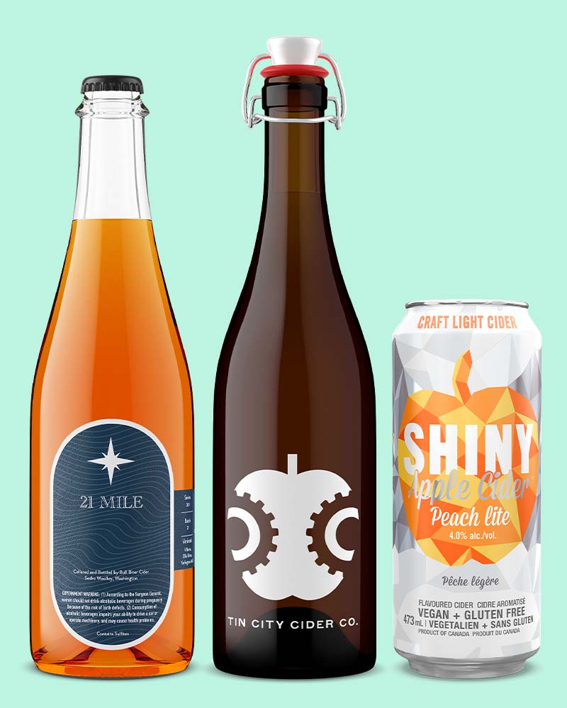 750mL apple cider bottles next to a cider can made with apple and peaches on a light green background