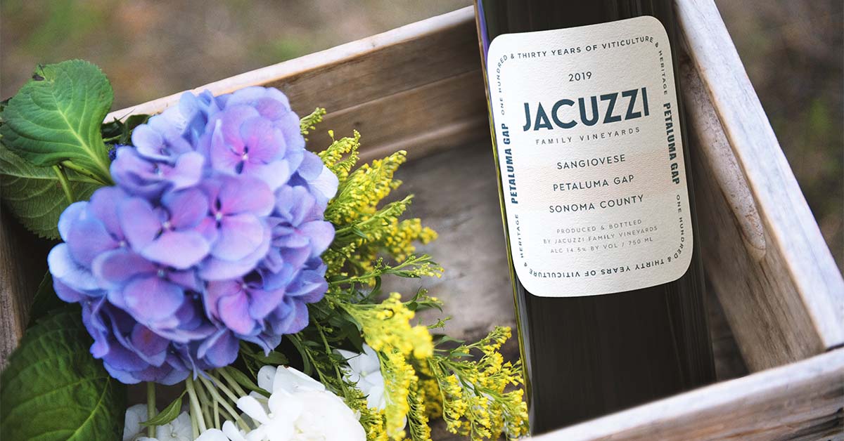 wine bottle in a wooden box with lilacs