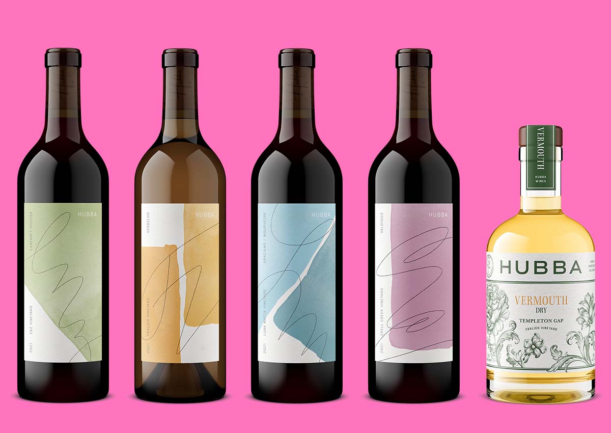 Five Hubba wine bottles with vibrant label designs arranged in a product lineup, rendered by Outshinery for brand marketing