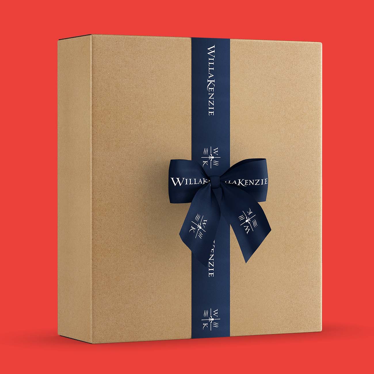 Kraft wine gift box wrapped with navy Willakenzie ribbon and bow, styled on red background for holiday wine gifting.