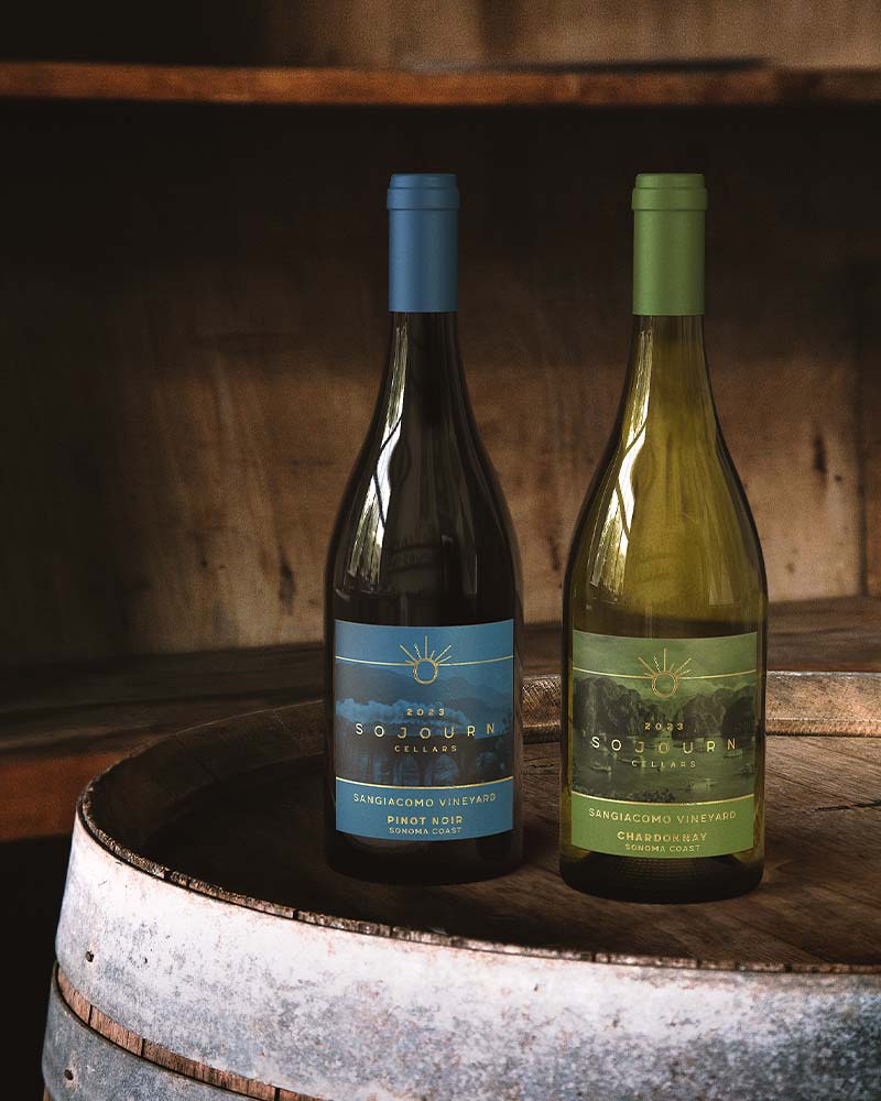 bottles of Pinot Noir and Chardonnay from Sonoma Valley on top of wine barrel