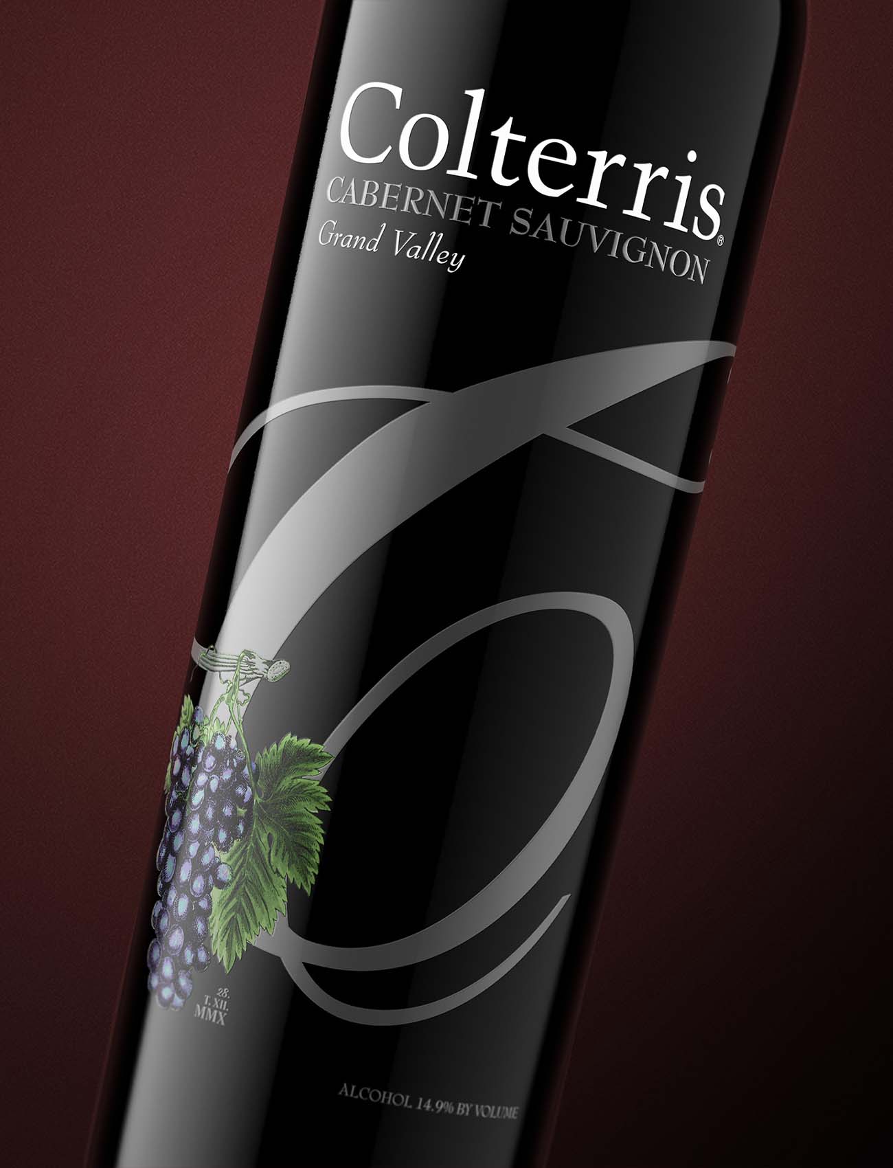 Close-up wine bottle product shot of Colterris Cabernet Sauvignon Grand Valley showing intricate label with calligraphic monogram and illustrated grape cluster