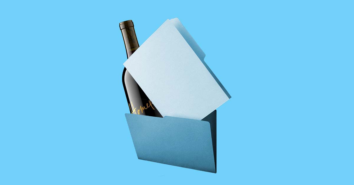Dark wine bottle tucked inside a manila folder on a blue background, illustrating how organized product image files speed up beverage launches
