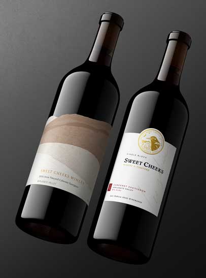 Sweet Cheeks Winery Cabernet Sauvignon 2020 and 2017 bottle shots, Applegate Valley labels on a charcoal backdrop, by Outshinery