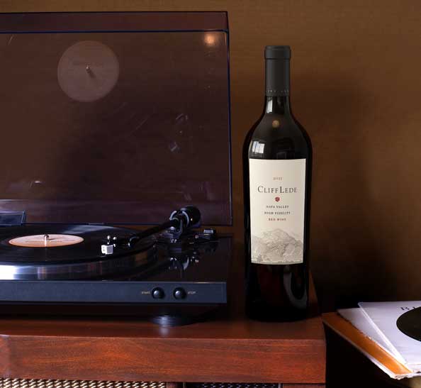 Cliff Lede High Fidelity 2022 Napa Valley red wine bottle beside a turntable and vinyl records, by Outshinery