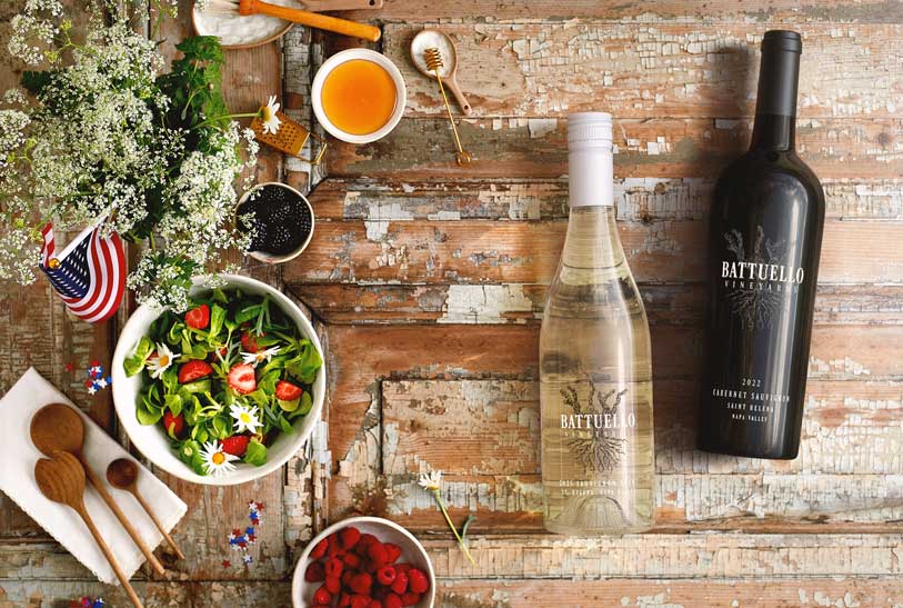 Battuello Vineyards Sauvignon Blanc 2025 and Cabernet Sauvignon 2022 bottles in an overhead summer picnic flat lay, by Outshinery