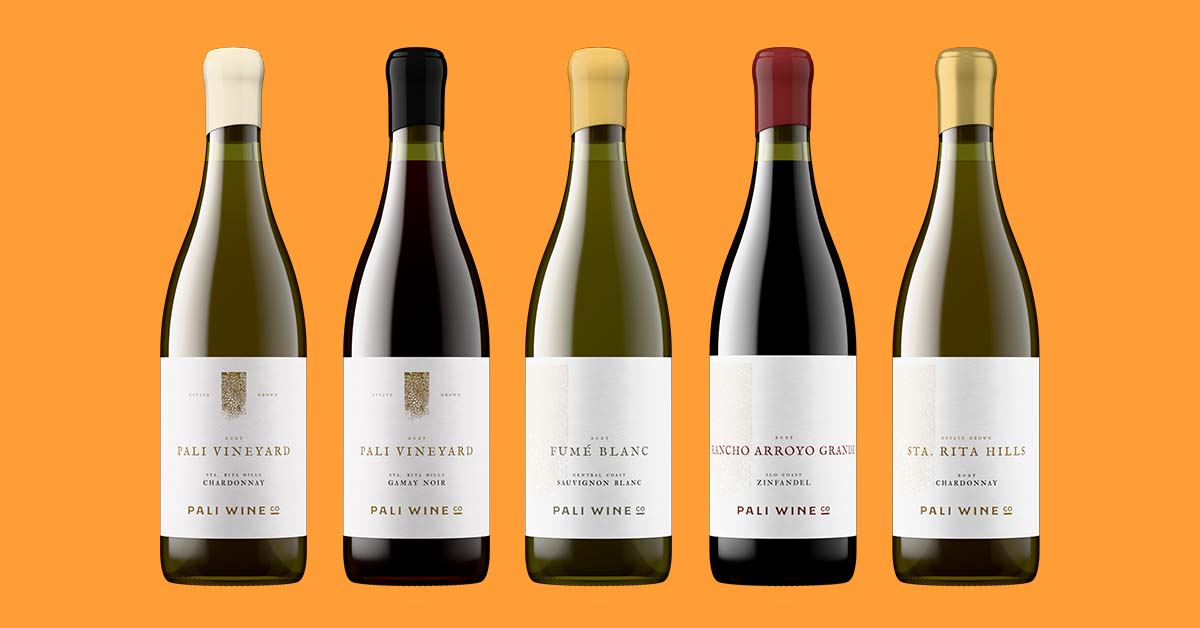 Five wine bottles in a row on an orange background, whites and reds with different capsule colors, each bottle shot generated from the same fixed camera and lighting setup