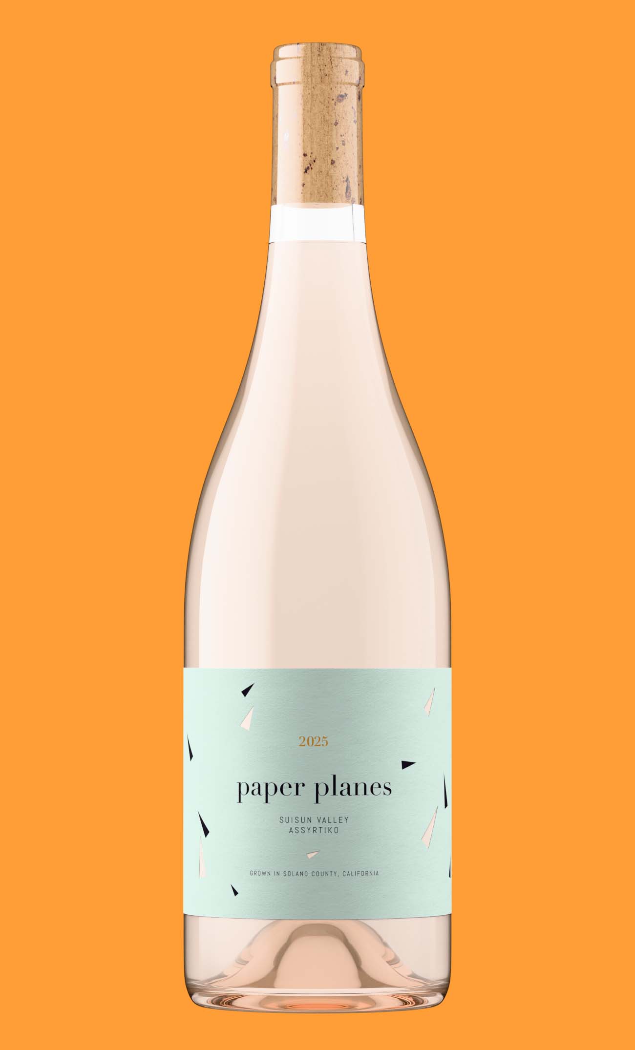 Pale wine in a clear flint bottle with a natural cork and a mint green label, the case where liquid color choice matters most in a bottle shot